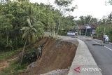 Pengendara motor melintasi jalan longsor di Desa Neglasari, Kabupaten Ciamis, Jawa Barat, Jumat (25/4/2025). Intensitas curah hujan tinggi di wilayah Kabupaten Ciamis mengakibatkan jalan alternatif yang menghubungkan Ciamis dengan Kabupaten Pangandaran dan Kabupaten Tasikmalaya longsor dan hanya bisa dilalui satu jalur atau buka tutup serta tidak bisa dilewati saat hujan deras. ANTARA FOTO/Adeng Bustomi/agr