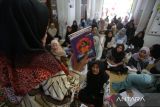 Seorang relawan (kiri) memberikan pelajaran penulisan cerita pendek  kepada peserta didik paket C  setara jenjang SMA  di Pusat Kegiatan Belajar Masyarakat (PKBM) Ruman Aceh, di Banda Aceh, Jumat (25/4/2025). Pusat Kegiatan Belajar Masyarakat (PKB) Ruman Aceh tahun ajaran 2025 menerima sebanyak 672 peserta didik paket A, paket B dan paket C  dari golong masyarakat miskin yang tidak mendapatkan pendidikan formal dengan biaya pendidikan gratis dalam upaya menyukseskan program pendidikan nasional. ANTARA FOTO/Ampelsa.