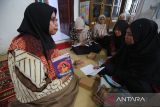 Seorang relawan (kiri) memberikan pelajaran penulisan cerita pendek  kepada peserta didik paket C  setara jenjang SMA  di Pusat Kegiatan Belajar Masyarakat (PKBM) Ruman Aceh, di Banda Aceh, Jumat (25/4/2025). Pusat Kegiatan Belajar Masyarakat (PKB) Ruman Aceh tahun ajaran 2025 menerima sebanyak 672 peserta didik paket A, paket B dan paket C  dari golong masyarakat miskin yang tidak mendapatkan pendidikan formal dengan biaya pendidikan gratis dalam upaya menyukseskan program pendidikan nasional. ANTARA FOTO/Ampelsa.