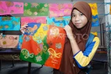 Siswa dari SD Negeri 007 Balikpapan Barat menunjukkan kain batik karyanya seusai proses pewarnaan di rumah produksi Batik Shaho, Balikpapan, Kalimantan Timur, Sabtu (26/4/2025). Kegiatan edukasi membatik itu diikuti puluhan siswa bertujuan sebagai pembelajaran sekaligus upaya menanamkan rasa bangga dan untuk melestarikan batik sebagai warisan budaya Indonesia. Antara Kaltim/Aditya Nugroho/mrh