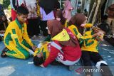 Anggota Usaha Kesehatan Sekolah (UKS) memberikan pengobatan terhadap rekannya yang mengalami luka saat simulasi gempa dan tsunami di SMA Negeri 6  Banda Aceh, Aceh, Sabtu (26/4/2025). Simulasi mandiri yang melibatkan 350 siswa sebagai agenda rutin setiap bulan di sekolah itu guna meningkatkan kewaspadaan dan pengurangan resiko korban jiwa jika terjadi bencana gempa dan tsunami dan sekaligus dalam rangka memperingati Hari Kesiapsiagaan Bencana Nasional . ANTARA FOTO/Ampelsa.