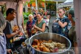 Wisatawan mancanegara membeli kuliner khas Kota Bandung saat Festival Kuliner dan Sentra Industri di Cihampelas Walk, Bandung, Jawa Barat, Minggu (27/4/2025). Pemerintah Kota Bandung menggelar Festival Kuliner dan Sentra Industri yang diikuti 20 UMKM dari delapan sentra industri di Kota Bandung serta 19 UMKM dari industri kuliner yang digelar untuk meningkatkan pendapatan dan menciptakan lapangan kerja sebanyak-banyaknya. ANTARA FOTO/Raisan Al Farisi/agr