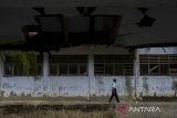 Seorang siswa berjalan di dekat ruang kelas yang rusak di SMP Negeri 2 Cimanuk, Pandeglang, Banten, Senin (28/4/2025). Pihak sekolah menuturkan, sebanyak empat ruang kelas mengalami kerusakan parah dan tiga kelas lainnya rusak ringan sejak sekitar empat tahun terakhir yang mengakibatkan proses belajar mengajar harus dipindahkan ke ruangan lain, serta terpaksa membatasi daya tampung murid karena kekurangan ruang kelas. ANTARA FOTO/Angga Budhiyanto/gp