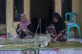 Perajin menyelesaikan pembuatan anyaman berbahan dasar daun pandan di Desa Wisata Bandung Bukit Sinyonya, Pandeglang, Banten, Senin (28/4/2025). Berdasarkan data dari Direktorat Jenderal Perbendaharaan Kementerian Keuangan, pemerintah telah menyalurkan dana desa sebesar Rp20,8 triliun dari pagu Rp69 triliun hingga 15 April 2025 kepada sebanyak 75.259 desa di 37 provinsi dengan tujuan untuk meningkatkan kesejahteraan masyarakat desa dan mengurangi kesenjangan pembangunan antara daerah perkotaan dan perdesaan. ANTARA FOTO/Angga Budhiyanto/gp