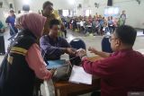 Warga menerima bantuan saat penyaluran bantuan sosial biaya hidup, santunan kematian, dan bantuan alat bantu disabilitas di Kelurahan Semampir, Kota Kediri, Jawa Timur, Senin (28/4/2025). Pemerintah daerah setempat menyerahkan bantuan sosial biaya hidup kepada 18 lansia, santunan kematian kepada 111 ahli waris, dan alat bantu disabilitas kepada 21 orang sebagai upaya mewujudkan Kota Ramah Disabilitas. Antara Jatim/Prasetia Fauzani/um