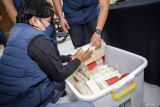 Petugas memasukkan barang bukti ke dalam kotak saat ungkap kasus narkotika di Polda Jatim, Surabaya, Jawa Timur, Selasa (29/4/2025). Direktorat Reserse Narkoba Polda Jatim mengungkap peredaran narkotika jaringan internasional Iran senilai kurang lebih Rp22 miliar dengan mengamankan dua tersangka dengan barang bukti 22 kilogram sabu, dua buah ponsel, dan uang tunai Rp100 ribu. Antara Jatim/Rizal Hanafi/um