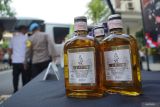 Polisi mengeluarkan barang bukti ratusan botol minuman keras (miras) dari dalam mobil saat ungkap kasus peredaran miras di Polres Jombang, Jawa Timur, Selasa (29/4/2025). Satreskoba Polres Jombang berhasil menganggalkan pengiriman miras sebanyak 716 botol miras berbagai merk dari Grobogan Jawa Tengah ke Kabupaten Jombang, serta mengamankan tiga orang tersangka satu warga Grobogan dan dua orang warga Jombang. Antara Jatim/Syaiful Arif/um