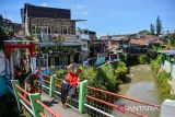 Dua orang penari mengelilingi permukiman padat sambil menari di kawasan Cibeunying Kidul, Bandung, Jawa Barat, Selasa (29/4/2025). Bongkeng Art Space menggelar pertunjukan 24 jam menari sejak 28 April pukul 19.00 hingga 29 April pukul 19.00 yang melibatkan puluhan penari dari berbagai kota di Jawa Barat dalam rangka memperingati Hari Tari Dunia. ANTARA FOTO/Raisan Al Farisi/agr