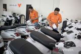 Pramuniaga memeriksa komponen motor listrik di salah satu dealer di Ngamprah, Kabupaten Bandung Barat, Jawa Barat, Selasa (29/4/2025). Wakil Menteri Perindustrian (Wamenperin) Faisol Riza menyatakan insentif yang diberikan untuk pembelian motor listrik pada tahun ini tertunda imbas adanya kebijakan tarif resiprokal yang hendak diterapkan oleh Presiden Amerika Serikat (AS) Donald Trump. ANTARA FOTO/Abdan Syakura/agr
