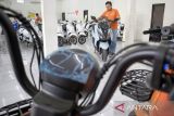 Pramuniaga memeriksa komponen motor listrik di salah satu dealer di Ngamprah, Kabupaten Bandung Barat, Jawa Barat, Selasa (29/4/2025). Wakil Menteri Perindustrian (Wamenperin) Faisol Riza menyatakan insentif yang diberikan untuk pembelian motor listrik pada tahun ini tertunda imbas adanya kebijakan tarif resiprokal yang hendak diterapkan oleh Presiden Amerika Serikat (AS) Donald Trump. ANTARA FOTO/Abdan Syakura/agr
