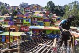 Petugas mengerjakan proyek penataan dan pengecatan permukiman di kawasan Kampung Pelangi 200, Bandung, Jawa Barat, Selasa (29/4/2025). Pemerintah Kota Bandung mengecat sedikitnya 300 unit rumah warga di kawasan tersebut untuk menjadi salah satu kawasan wisata kota sekaligus mengubah kesan tata permukiman yang kumuh dengan target selesai pada awal Mei 2025. ANTARA FOTO/Novrian Arbi/agr