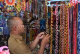 Seorang pengunjung melihat kalung manik-manik Dayak yang dijual di area UMKM kegiatan Naik Dango ke-2 di Rumah Radakng, Pontianak, Kalimantan Barat, Senin (28/4/2025). Beragam aksesoris seperti kalung, gelang dan hiasan baju dari manik-manik Dayak yang dibuat oleh perajin Dayak Pontianak tersebut dijual seharga Rp15 ribu hingga ratusan ribu per buah. ANTARA FOTO/Jessica Wuysang/nz 
