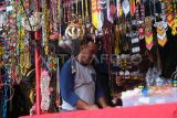 Seorang pedagang merapikan aksesoris manik-manik Dayak yang dijualnya di area UMKM kegiatan Naik Dango ke-2 di Rumah Radakng, Pontianak, Kalimantan Barat, Senin (28/4/2025). Beragam aksesoris seperti kalung, gelang dan hiasan baju dari manik-manik Dayak yang dibuat oleh perajin Dayak Pontianak tersebut dijual seharga Rp15 ribu hingga ratusan ribu per buah. ANTARA FOTO/Jessica Wuysang/nz 