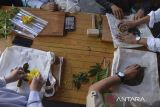 Wisatawan membuat ecoprint dari kantong body bag di rumah produksi Batik Dahon, Desa Margacinta, Kabupaten Pangandaran, Jawa Barat, Selasa (29/4/2025). Berawal dari kepedulian terhadap lingkungan, perajin Batik Dahon per bulan memproduksi sebanyak 40 lembar kain, baju, sepatu, tas, dan topi pewarna alami dari tumbuhan serta menggembangkan usahanya melalui wisata edukasi ecoprint dengan omset mencapai Rp40 juta per bulan yang dipasarkan di Bandung, Jakarta dan kerap kali dijadikan oleh-oleh wisata mancanegara. ANTARA FOTO/Adeng Bustomi/agr