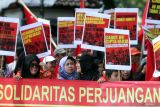 Buruh membawa poster saat mengikuti aksi Hari Buruh Internasional di depan Gedung DPRD, Malang, Jawa Timur, Kamis (1/5/2025). Unjuk rasa gabungan dari Solidaritas Perjuangan Buruh Indonesia (SPBI) dan berbagai elemen mahasiswa tersebut menuntut pemerintah memperjuangkan kesejahteraan buruh dengan membuka lapangan kerja baru serta mencegah Pemutusan Hubungan Kerja (PHK) sepihak. ANTARA Jatim/Ari Bowo Sucipto/mas.