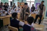 Wakil Menteri Pendidikan Dasar dan Menengah (Wamendikdasmen) Atip Latipulhayat (kedua kanan) didampingi Wakil Bupati Kabupaten Bandung Ali Syakieb (kanan) berbincang dengan siswa saat kunjungan kerja di SD IT Persis Ciganitri, Kabupaten Bandung, Jawa Barat, Jumat (2/5/2025). Dalam kunjungan yang bertepatan dengan momentum Hari Pendidikan Nasional tersebut, Wamendikdasmen juga menyalurkan program perbaikan sarana dan prasarana pendidikan serta meninjau pelaksanaan program digitalisasi pembelajaran yang merupakan bagian dari Program Hasil Terbaik Cepat (PHTC) Presiden Prabowo Subianto. ANTARA FOTO/Abdan Syakura/agr
