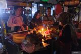 Pedagang melayani pembeli menggunakan penerangan lilin saat terjadi gangguan pasokan listrik di Denpasar, Bali, Jumat (2/5/2025). Perusahaan Listrik Negara (PLN) Unit Induk Distribusi Bali melakukan investigasi penyebab padamnya listrik yang terjadi di seluruh Bali pada Jumat (2/5) sejak pukul 16.09 wita hingga berita ini diturunkan. ANTARA FOTO/Nyoman Hendra Wibowo/wsj.