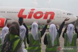 Petugas bandara melambaikan tangan kepada Jamaah Calon Haji Kloter Pertama Embarkasi Banjarmasin di Bandara Syamsudin Noor Banjarmasin, Banjarbaru, Provinsi Kalimantan (Kalsel), Senin (5/5/2025). Sebanyak 423 orang calon haji Kloter Pertama asal Kalsel mulai diberangkatkan menuju Madinah, Arab Saudi menggunakan pesawat Lion Air Airbus 330. ANTARA/Muhammad Iqbal 