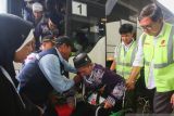 Petugas Penyelenggara Ibadah Haji (PPIH) membantu seorang calon haji Kloter Pertama Embarkasi Banjarmasin yang menggunakan kursi roda di Bandara Syamsudin Noor Banjarmasin, Banjarbaru, Provinsi Kalimantan Selatan (Kalsel), Senin (5/5/2025). Sebanyak 423 orang calon haji Kloter Pertama asal Kalsel mulai diberangkatkan menuju Madinah, Arab Saudi menggunakan pesawat Lion Air Airbus 330. ANTARA/Muhammad Iqbal 