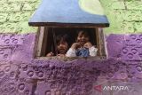 Anak-anak melihat dari jendela rumahnya yang telah diwarnai usai peresmian Lembur Katumbiri di Bandung, Jawa Barat, Selasa (6/5/2025). Pemerintah Kota Bandung meresmikan Kawasan yang dulu bernama Kampung Pelangi 200 menjadi Lembur Katumbiri dengan memberi warna sebanyak 347 rumah sebagai kawasan wisata yang rapi, inklusif, dan bernilai edukatif berbasis kearifan lokal dan kemasyarakatan. ANTARA FOTO/Novrian Arbi ANTARA FOTO/Novrian Arbi/agr
