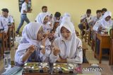 Siswa menyantap Makan Bergizi Gratis (MBG) di SMA Negeri 1 Pangandaran, Jawa Barat, Selasa (6/5/2025). Kementerian Keuangan (Kemenkeu) mencatat realisasi belanja program MBG mencapai Rp2,3 triliun per 29 April 2025 dengan jumlah penerima telah mencapai 3,26 juta orang yang dilayani oleh 1.100 Satuan Pelayanan Pemenuhan Gizi (SPPG). ANTARA FOTO/Adeng Bustomi/agr
