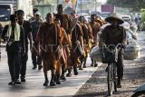 Sejumlah biksu yang mengikuti ritual Thudong berjalan kaki di Jalan Raya Soekarno Hatta, Kabupaten Kendal, Jawa Tengah, Senin (5/5/2025). Sebanyak 36 biksu yang melakukan perjalanan ritual Thudong dari Thailand menuju Candi Borobudur untuk menyambut Hari Raya Waisak pada 12 Mei 2025, tiba di Kabupaten Kendal dan akan bermalam di Gereja St Antonius Padua. ANTARA FOTO/Aprillio Akbar/foc.