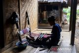 Wanita Suku Badui menenun kain di Desa Kanekes, Lebak, Banten, Rabu (7/5/2025). Pemasaran kain tenun khas Suku Badui tersebut kini telah menembus pasar internasional seperti Cina dengan perputaran uang dapat mencapai hingga Rp700 juta per bulan atau sebanyak 2.500 unit potong kain per per bulannya. ANTARA FOTO/Muhammad Bagus Khoirunas/gp
