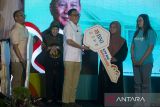 Menteri Perlindungan Pekerja Migran Indonesia Abdul Kadir Karding (tengah) menyerahkan kunci rumah secara simbolis kepada perwakilan keluarga pekerja migran disaksikan Dirjen Perumahan Perdesaan Kementerian Perumahan dan Kawasan Permukiman Imran (kiri) dan Kepala Badan Pusat Statistik (BPS) Amalia Adininggar Widyasanti (kedua kiri) usai penandatanganan kerja sama pembiayaan rumah subsidi di Pegaden, Subang, Jawa Barat, Kamis (8/5/2025). PT Bank Negara Indonesia (Persero) Tbk bekerja sama dengan Kementerian Perumahan dan Kawasan Permukiman (PKP) serta Kementerian Perlindungan Pekerja Migran Indonesia (KP2MI) untuk memberikan solusi pembiayaan rumah bersubsidi bagi 20.000 Pekerja Migran Indonesia (PMI). ANTARA FOTO/Dedhez Anggara/agr
