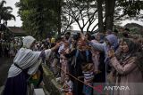 Seorang jamaah calon haji menyapa keluarga dan sanak saudara sebelum pemberangkatan ke Asrama Haji Bekasi di Pusdikkav, Padalarang, Kabupaten Bandung Barat, Jawa Barat, Kamis (8/5/2025). Sebanyak 441 calon haji asal Kabupaten Bandung Barat yang tergabung dalam kelompok terbang (kloter) tujuh belas embarkasi Bekasi diberangkatkan menuju Asrama Haji Bekasi untuk selanjutnya diterbangkan ke Madinah, Arab Saudi pada Jumat (9/5) melalui Bandara Internasional Soekarno-Hatta. ANTARA FOTO/Abdan Syakura/agr