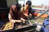 Dua orang siswa menyiapkan bibit tanaman kangkung yang dibudidayakan menggunakan sistem akuaponik di SMK Pawyata Daha 2, Kota Kediri, Jawa Timur, Jumat (9/5/2025). Pelatihan akuaponik atau sistem pertanian yang menggabungkan budidaya tanaman dengan budidaya ikan tersebut merupakan praktik program kewirausahan sebagai upaya mendukung ketahanan pangan. ANTARA Jatim/Prasetia Fauzani/mas.