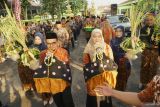 Suasana iring-iringan pengarak sepasang boneka pengantin dalam ritual manten tebu di PG Modjopanggung, Tulungagung, Jawa Timur, Jumat (9/5/2025). Tradisi manten tebu merupakan ritual adat budaya yang ada sejak era kolonial Belanda dan sampai kini terus dilestarikan untuk menandai dimulainya musim giling tebu sekaligus sebagai simbol sinergi antara pabrik gula dengan petani tebu. ANTARA Jatim/Destyan Sujarwoko/mas.