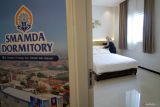 Seorang siswa merapikan kamar salah satu gedung Smamda Dormitory di Sidoarjo, Jawa Timur, Sabtu (10/5/2025. Menteri Pendidikan Dasar dan Menengah (Mendikdasmen) Abdul Mu'ti meresmikan bangunan asrama dengan 49 kamar dilengkapi 2 hall tersebut bertujuan untuk meningkatkan layanan tempat tinggal nyaman bagi siswa dan mendukung pengembangan karakter serta pembelajaran. Antara Jatim/Umarul Faruq