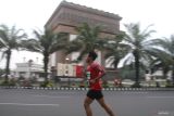 Seorang peserta berlari dengan latar belakang monumen Simpang Lima Gumul saat mengikuti Kediri Half Marathon 2025 di Kabupaten Kediri, Jawa Timur, Minggu (11/5/2025). Lomba lari tahunan dengan rute melewati bangunan ikonik Monumen Simpang Lima Gumul tersebut terbagi dalam lima kategori dengan menempuh jarak 21 kilometer, 10 kilometer, dan 5 kilometer. ANTARA Jatim/Prasetia Fauzani/mas.
