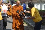 Bhikkhu (biksu) menerima derma makanan dari umat saat menjalani tradisi pindapata di sekitar Vihara Buddha Loka Tulungagung, Jawa Timur, Minggu (11/5/2025). Pindapata merupakan tradisi penting dalam agama Buddha, yang kemudian menjadi rangkaian wajib dalam menyongsong Tri Suci Waisak, dimana para bhikkhu (biksu) berjalan kaki dari satu tempat ke tempat lain untuk menerima derma makanan dari umat. ANTARA Jatim/Destyan Sujarwoko/mas.