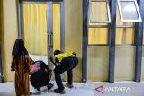 Keluarga korban ledakan mengintip ke dalam Ruang Jenazah di RSUD Pameungpeuk, di Kabupaten Garut, Jawa Barat, Senin (12/5/2025). RSUD Pameungpeuk melakukan autopsi dan identifikasi terhadap 13 korban ledakan pemusnahan amunisi tak layak pakai di Desa Sagara Kecamatan Cibalong Kabupaten Garut yang terdiri dari empat orang anggota TNI dan sembilan masyarakat sipil. ANTARA FOTO/Raisan Al Farisi/agr