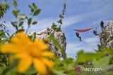 Wisatawan didampingi instruktur meniti tali untuk menaiki tempat tidur gantung (hammock) di Tebing Hawu, Padalarang, Kabupaten Bandung Barat, Jawa Barat, Senin (12/5/2025). Wisata ekstrem hammock di ketinggian sekitar 50 meter dari atas tanah dengan panorama perbukitan dan persawahan tersebut menjadi salah satu kegiatan wisata luar ruang favorit masyarakat untuk mengisi libur panjang Hari Raya Waisak 2025. ANTARA FOTO/Abdan Syakura/agr