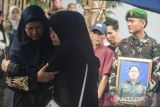 Keluarga Almarhum Mayor (Cpl) Anda Rohanda menangis saat mengikuti prosesi upacara pemakaman militer di pemakaman keluarga, Cinunuk, Kabupaten Bandung, Jawa Barat, Selasa (13/5/2025). Prajurit Gupusmu III Jakarta tersebut merupakan salah satu dari 13 korban jiwa dalam musibah ledakan saat pemusnahan amunisi tidak layak pakai di Desa Sagara, Kecamatan Cibalong, Kabupaten Garut pada Senin (12/5) lalu. ANTARA FOTO/Novrian Arbi/agr