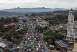 Foto udara antrean kendaraan saat diberlakukan sistem satu arah (one way) di Jalan Raya Puncak, Gadog, Kabupaten Bogor, Jawa Barat, Senin (12/5/2025). Pada libur panjang Hari Raya Waisak, cuti bersama serta libur akhir pekan, kawasan wisata Puncak dipadati kendaraan wisatawan sehingga Satlantas Polres Bogor menerapkan rekayasa arus lalu lintas sistem satu arah (one way) dari arah Jakarta menuju Puncak untuk mengurai kemacetan kendaraan. ANTARA FOTO/Yulius Satria Wijaya/YU