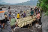 Relawan memasang jembatan bambu di jalur terdampak lahar hujan Gunung Semeru di Desa Jugosari, Kecamatan Candipuro, Lumajang, Jawa Timur, Kamis (15/5/2025). Pemkab Lumajang menetap masa tanggap darurat bencana selama 90 hari sejak tanggal 11 Mei 2025 untuk mempercepat penanganan kedaruratan infrastruktur di daerah aliran terdampak banjir lahar hujan Gunung Semeru. Antara Jatim/Irfan Sumanjaya/um