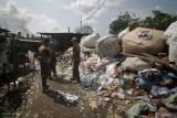 Petugas Satpol PP melihat sampah plastik sebagai bahan bakar tahu di salah satu pabrik tahu di Tropodo, Krian, Sidoarjo, Jawa Timur, Kamis (15/5/2025). Pabrik tahu di wilayah tersebut menggunakan sampah plastik dan spon karet sebagai bahan bakar karena harganya yang murah meski asap hasil pembakaran sampah plastik bisa mencemari udara. Antara Jatim/Umarul Faruq