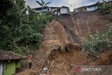 Warga berada di dekat material tanah longsor yang menimbun fasilitas umum dan kolam pemancingan di Lembang, Kabupaten Bandung Barat, Jawa Barat, Kamis (15/5/2025). Berdasarkan data BPBD Provinsi Jawa Barat, sebanyak tujuh rumah dan sejumlah kolam pemancingan serta fasilitas umum di empat desa di Kecamatan Lembang, Kabupaten Bandung Barat terdampak bencana longsor akibat tingginya intensitas hujan yang disertai angin kencang pada Rabu (14/5) sore. ANTARA FOTO/Abdan Syakura/agr