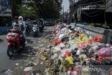 Pengendara sepeda motor melintas di samping tumpukan sampah di Jalan KH. Ahmad Dahlan, Cipondoh, Kota Tangerang, Banten, Kamis (15/5/2025). Sampah yang didominasi limbah rumah tangga tersebut menumpuk hingga berserakan ke tepi jalan akibat jumlah sampah yang dibuang lebih besar dari yang diangkut petugas kebersihan. ANTARA FOTO/Putra M. Akbar/gp