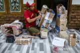Pekerja menyelesaikan produksi kostum robot dari limbah kardus bekas di rumah produksi WF Craft Miniatur, Kelurahan Tegal Bunder, Kota Cilegon, Banten, Kamis (15/5/2025). UMKM rumahan yang memanfaatkan bahan baku dari limbah seperti kardus bekas, stik es krim, dan kayu untuk dijadikan kerajinan miniatur kapal dan kostum robot bernilai tinggi tersebut dijual dengan harga Rp1-15 juta per buah dan telah dipasarkan hingga luar negeri yaitu di Amerika Serikat dan Peru. ANTARA FOTO/Muhammad Bagus Khoirunas/gp