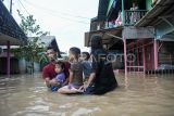 Warga menaiki ban karet saat banjir melanda kawasan Loa Janan Ilir, Samarinda, Kalimantan Timur, Selasa (13/5/2025). Berdasarkan data Kecamatan Loa Janan Ilir, sebanyak 18 lingkungan RT terendam banjir dengan ketinggian 30 cm hingga 150 cm akibat hujan dengan intensitas tinggi hingga air kiriman dari km 5 dan km 8, Kecamatan Loa Janan, Kutai Kartanegara. Antara Kaltim/M Risyal Hidayat