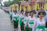 Umat Hindu berjalan menjunjung gebogan atau sesajen berisi buah, bunga, dan hiasan janur saat tradisi Mapeed di Pura Taman Ayun, Desa Mengwi, Badung, Bali, Kamis (15/5/2025). Tradisi yang digelar setiap enam bulan sekali dengan diikuti ratusan perempuan di desa tersebut merupakan rangkaian dari upacara persembahyangan di pura yang diakui UNESCO sebagai warisan budaya dunia. ANTARA FOTO/Nyoman Hendra Wibowo/wsj.