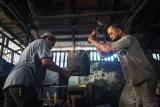 Pandai besi menyelesaikan pembuatan parang secara tradisional di Balikpapan, Kalimantan Timur, Kamis (15/5/2025). Menurut pandai besi yang masih mengandalkan peralatan tradisional tersebut, dalam sehari ia mampu memproduksi sebanyak 10 buah peralatan seperti parang, pisau, kapak, dan sabit yang dijual dengan harga Rp150 ribu hingga Rp600 ribu per buah. Antara Kaltim/Aditya Nugroho/bar/mrh
