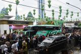 Sejumlah pejabat daerah dan warga melambaikan tangan pada jamaah calon haji di dalam bus saat pemberangkatan di Kota Madiun, Jawa Timur, Jumat (16/5/2025). Jumlah jamaah calon haji 2025 dari Kota Madiun sebanyak 172 orang didampingi enam petugas haji berangkat ke Tanah Suci dengan tiga kloter yaitu 52, 52 dan 46 embarkasi Surabaya. Antara Jatim/Siswowidodo/um 