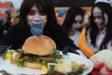 Peserta menunjukkan Burjak (burger dan rujak uleg) buatan timnya saat mengikuti Festival Rujak Uleg di Surabaya, Jawa Timur, Sabtu (17/5/2025). Festival Rujak Uleg rutin dilaksanakan setiap tahun untuk menyambut HUT ke-732 Kota Surabaya dan diikuti sekitar 131 tim peserta dari masyarakat umum, berbagai instansi dan mahasiswa mancanegara. Antara Jatim/Didik Suhartono/um 