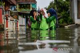 Siswi SMP melakukan swafoto saat melintasi banjir yang menggenangi kawasan permukiman di Kampung Bojongasih, Dayeuhkolot, Kabupaten Bandung, Jawa Barat, Jumat (16/5/2025). Hujan yang mengguyur Bandung Raya pada Kamis (15/5) mengakibatkan beberapa kampung di Desa Dayeuhkolot terendam air luapan Sungai Citarum setinggi 40 cm hingga 1 meter. ANTARA FOTO/Raisan Al Farisi/agr