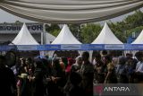 Pengunjung berdiri di depan stan UMKM binaan BUMDes pada Festival Bangun Desa Bangun Indonesia di Alun-alun Cikande, Kabupaten Serang, Banten, Jumat (16/5/2025). Kementerian Desa dan Pembangunan Daerah Tertinggal menggelar festival tersebut dengan menghadirkan beragam produk inovasi binaan Badan Usaha Milik Desa (BUMDes) dalam rangka mendorong pembangunan desa berkelanjutan sebagai bagian dari solusi atas tantangan lingkungan hidup yang semakin kompleks. ANTARA FOTO/Angga Budhiyanto/gp